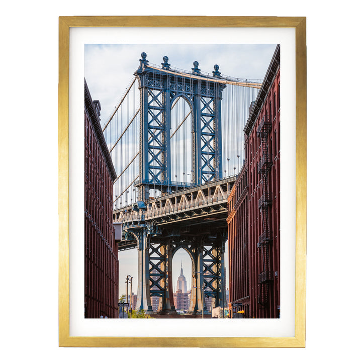 a large blue suspension bridge with intricate metalwork, spanning across a cityscape with red brick buildings on either side.