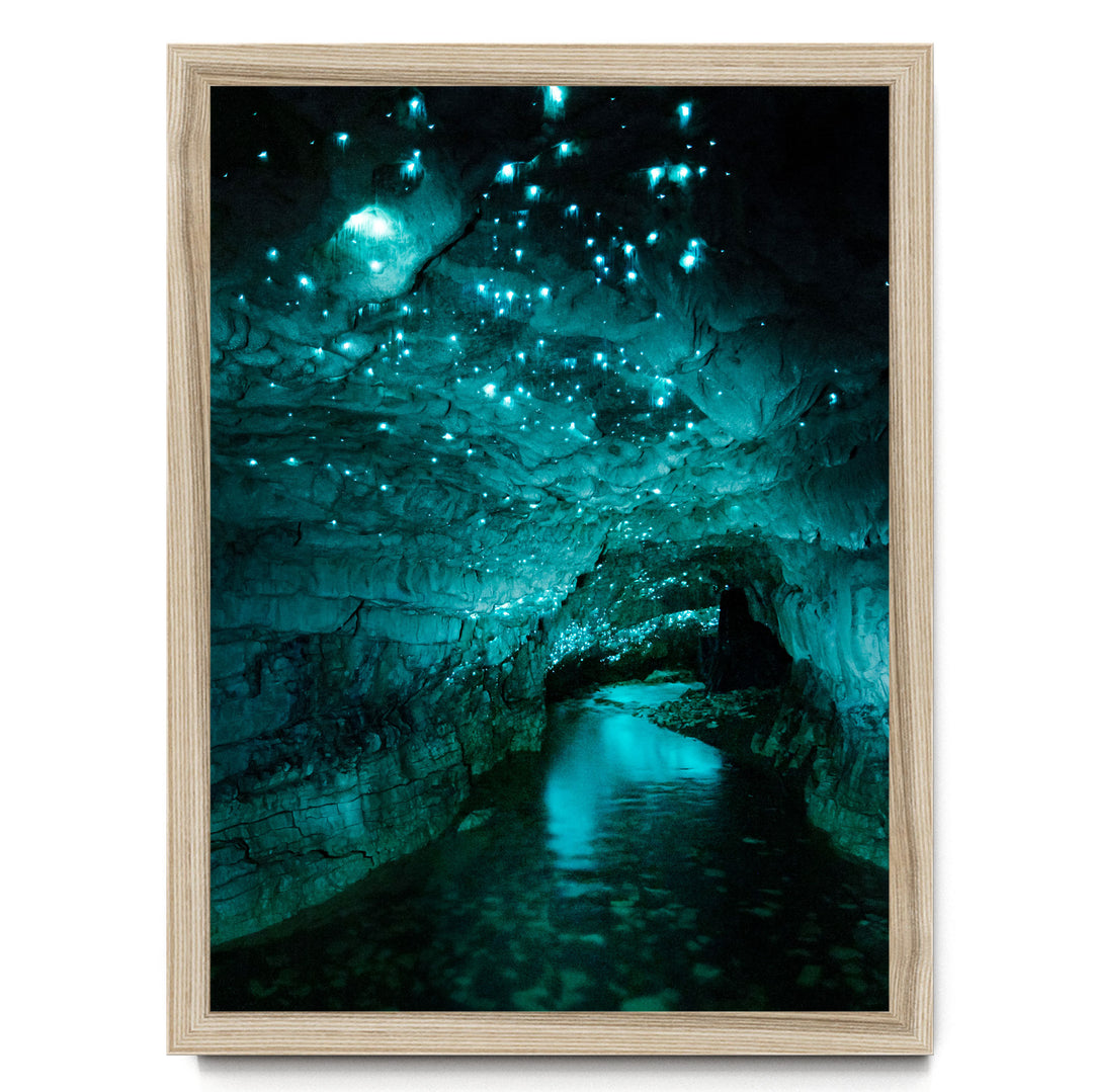 A cave with a stream of water flowing through it, illuminated by a mesmerizing display of blue and green lights that create a captivating, otherworldly atmosphere.
