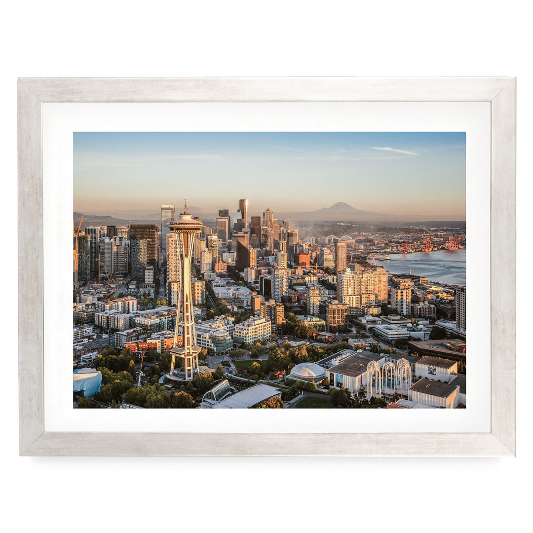 The image is a panoramic view of the Seattle skyline, showcasing the iconic Space Needle and the surrounding cityscape.