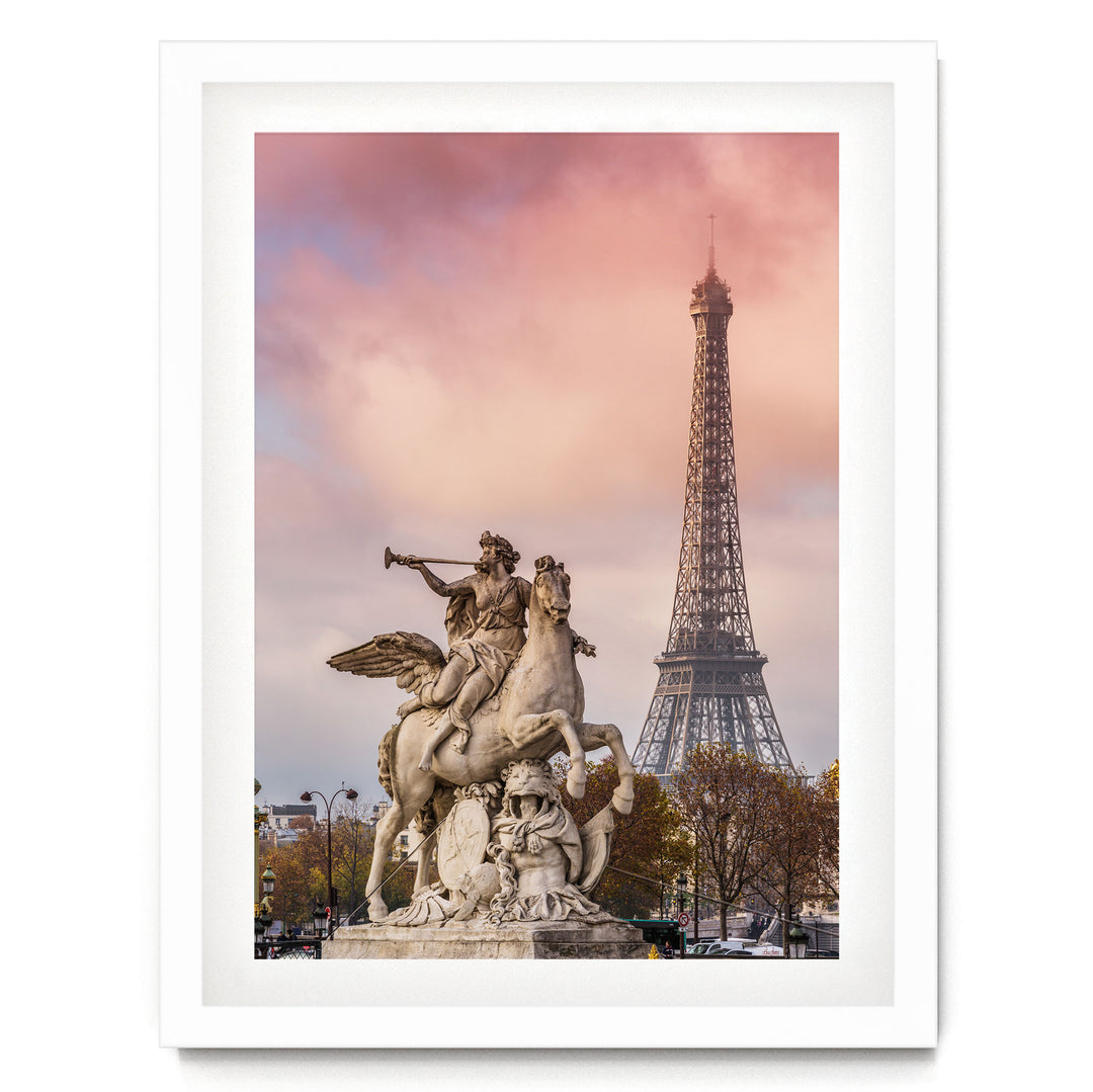 a large stone statue of a winged man riding a rearing horse, with the Eiffel Tower visible in the background against a pink and purple sky.