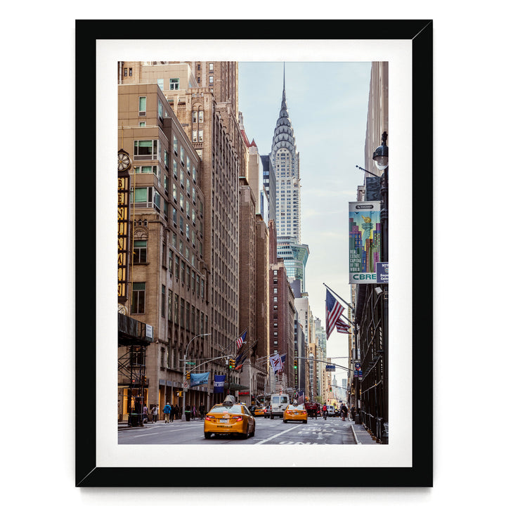 A bustling city street with tall buildings, including the iconic Chrysler Building, and yellow taxis driving down the road.