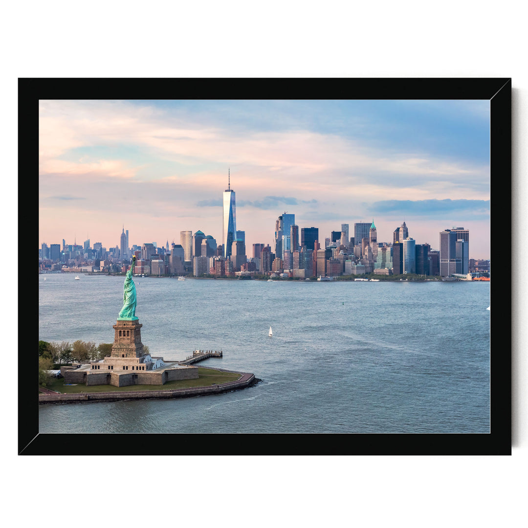 the Statue of Liberty on a small island in the foreground, with the New York City skyline visible in the background.