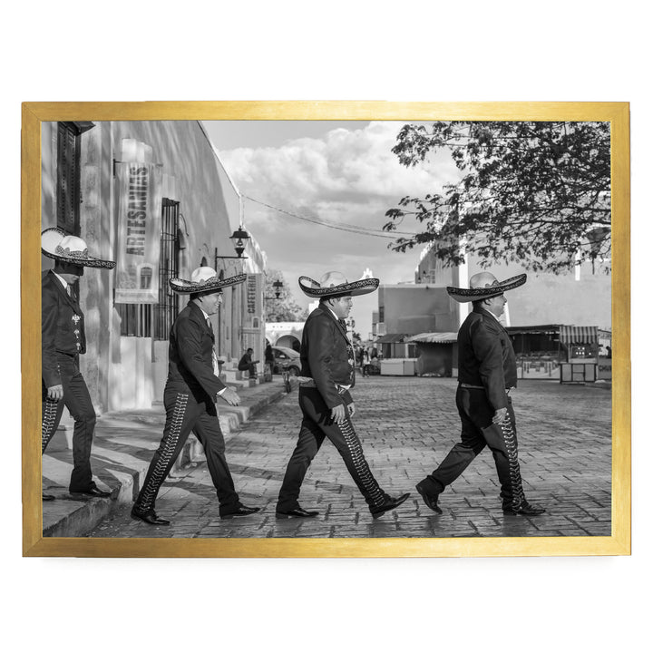 A group of men wearing sombreros walking down a street in a city.