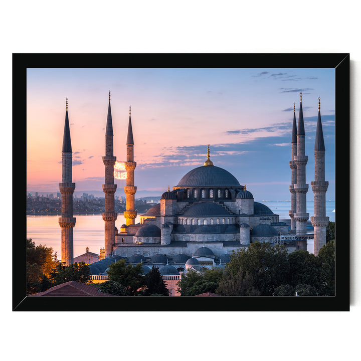 the Blue Mosque, also known as the Sultan Ahmed Mosque, in Istanbul, Turkey, with its distinctive domes and minarets silhouetted against a colorful sunset sky.