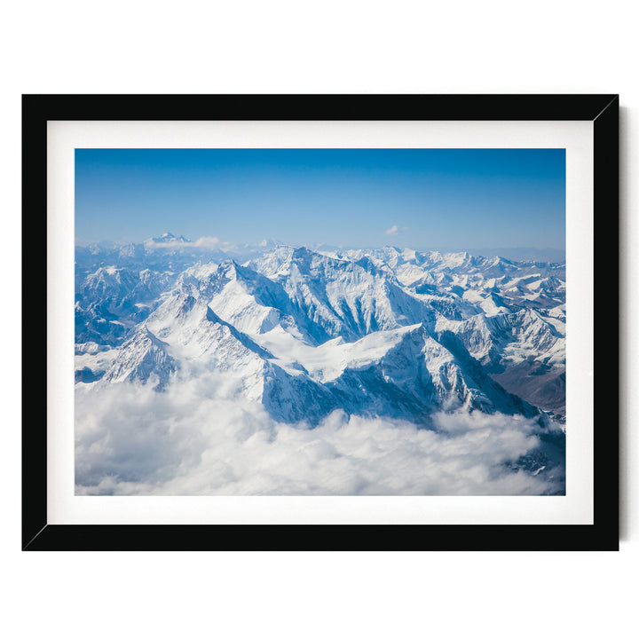 a breathtaking view of snow-capped mountains rising above a vast expanse of clouds, creating a stunning natural landscape.