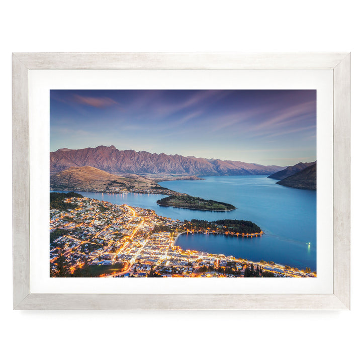 a picturesque town nestled at the foot of a mountain range, with a stunning view of the surrounding landscape and a serene lake.