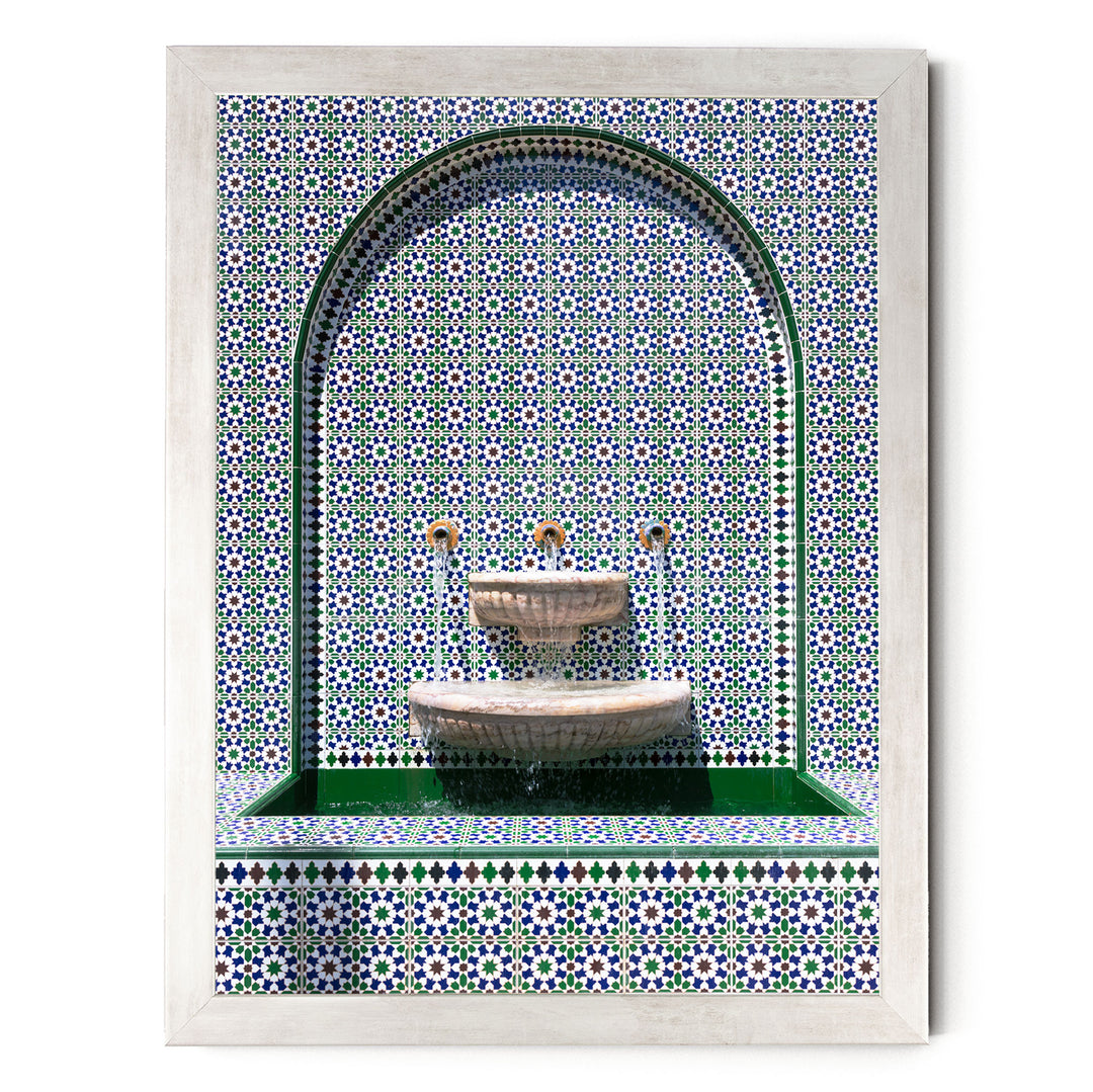 a decorative fountain with a tiled wall backdrop.