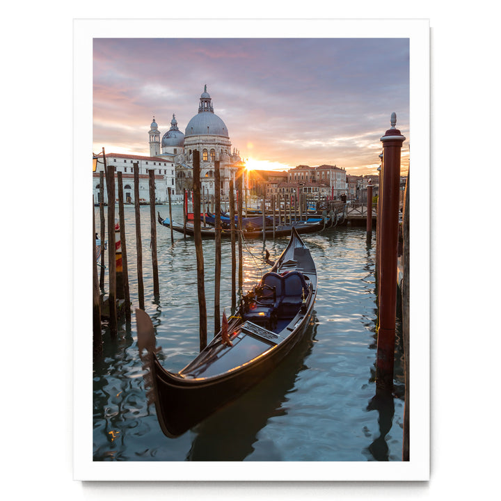 a serene scene of a gondola floating on the water, with a large domed building in the background, possibly a church or palace, as the sun sets and casts a warm glow over the scene.