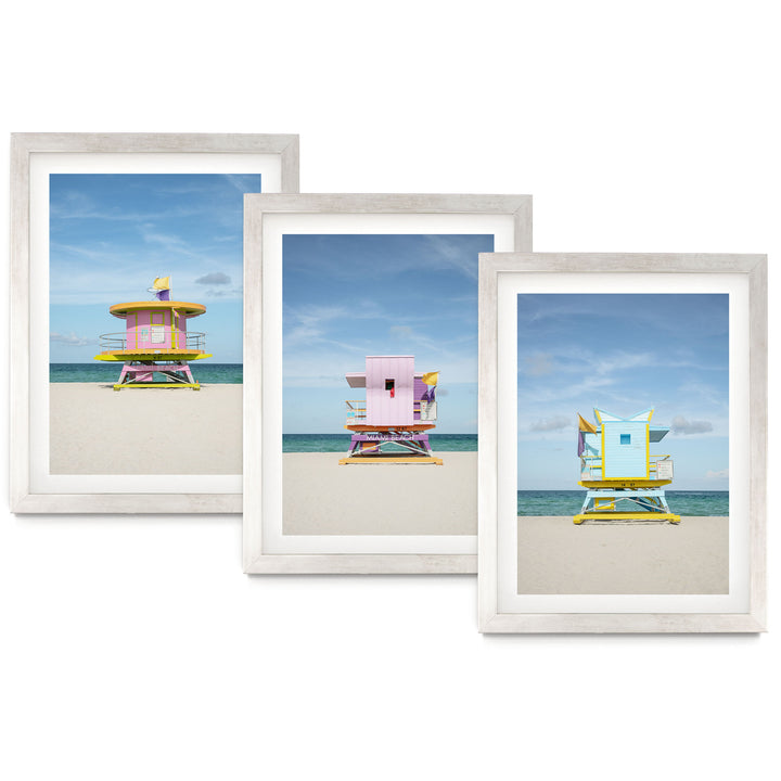 The image is a collage of three framed pictures, each depicting a lifeguard tower on a beach. The lifeguard towers are painted in various colors, including pink, yellow, and blue, and are situated on the sandy beach with the ocean in the background.