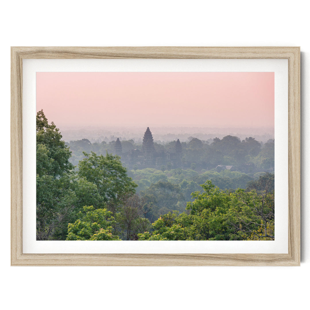 a serene landscape with a forested area and a distant temple or structure, possibly a pagoda, set against a hazy pink sky.