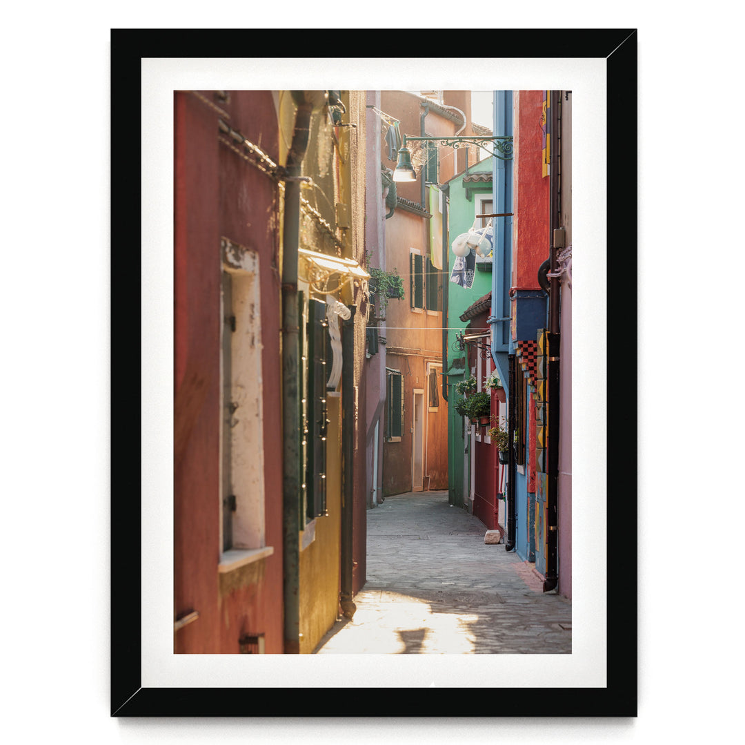 A narrow, colorful alleyway in a city, with buildings painted in various vibrant colors lining the sides.