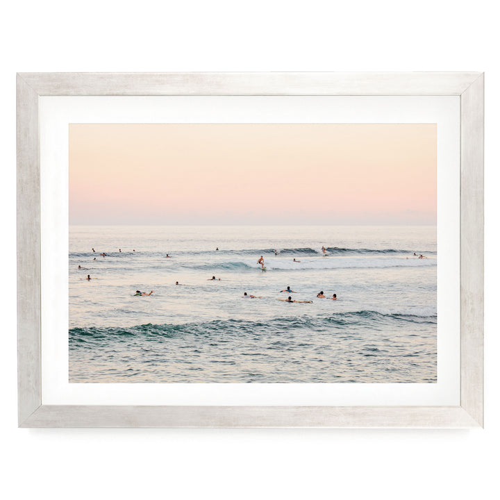 a group of people enjoying themselves in the ocean, with some of them riding waves on surfboards.