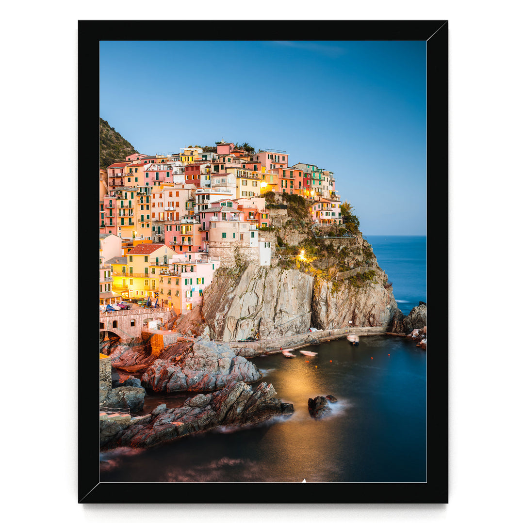 A picturesque coastal town nestled on a cliff, with colorful houses perched on the rocky outcropping overlooking the deep blue sea.