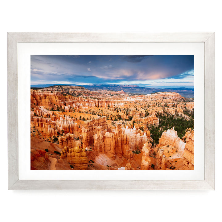 a breathtaking view of the rugged, orange-hued hoodoos of Bryce Canyon National Park, with a dramatic sky and clouds in the background.