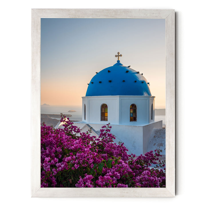 a blue domed church with a cross on top, surrounded by a vibrant display of purple flowers.