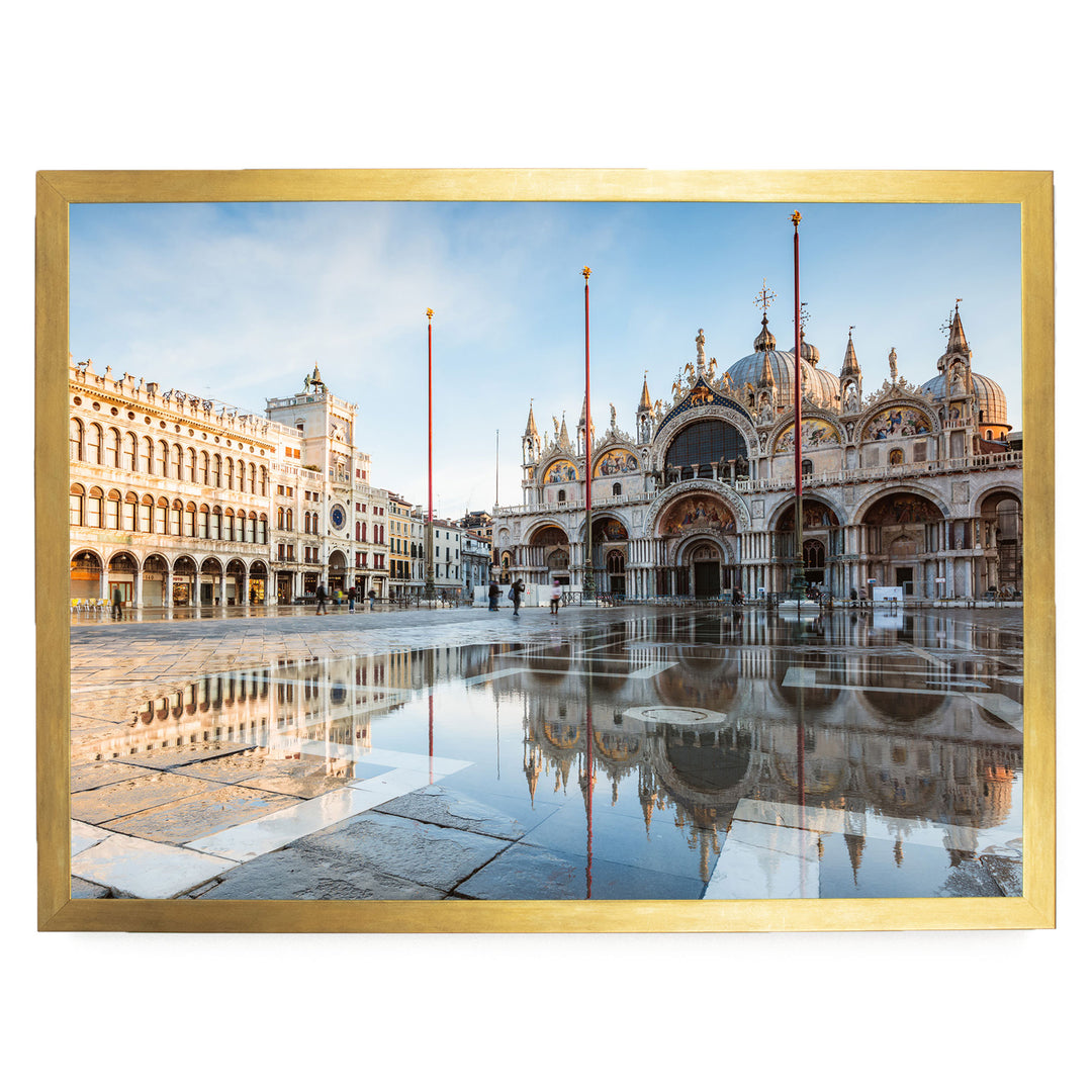 a large, ornate building with multiple domes and arches, reflecting in a large pool in the foreground. The building is surrounded by other buildings, creating a picturesque scene. The sky above is clear and blue, adding to the overall beauty of the image.