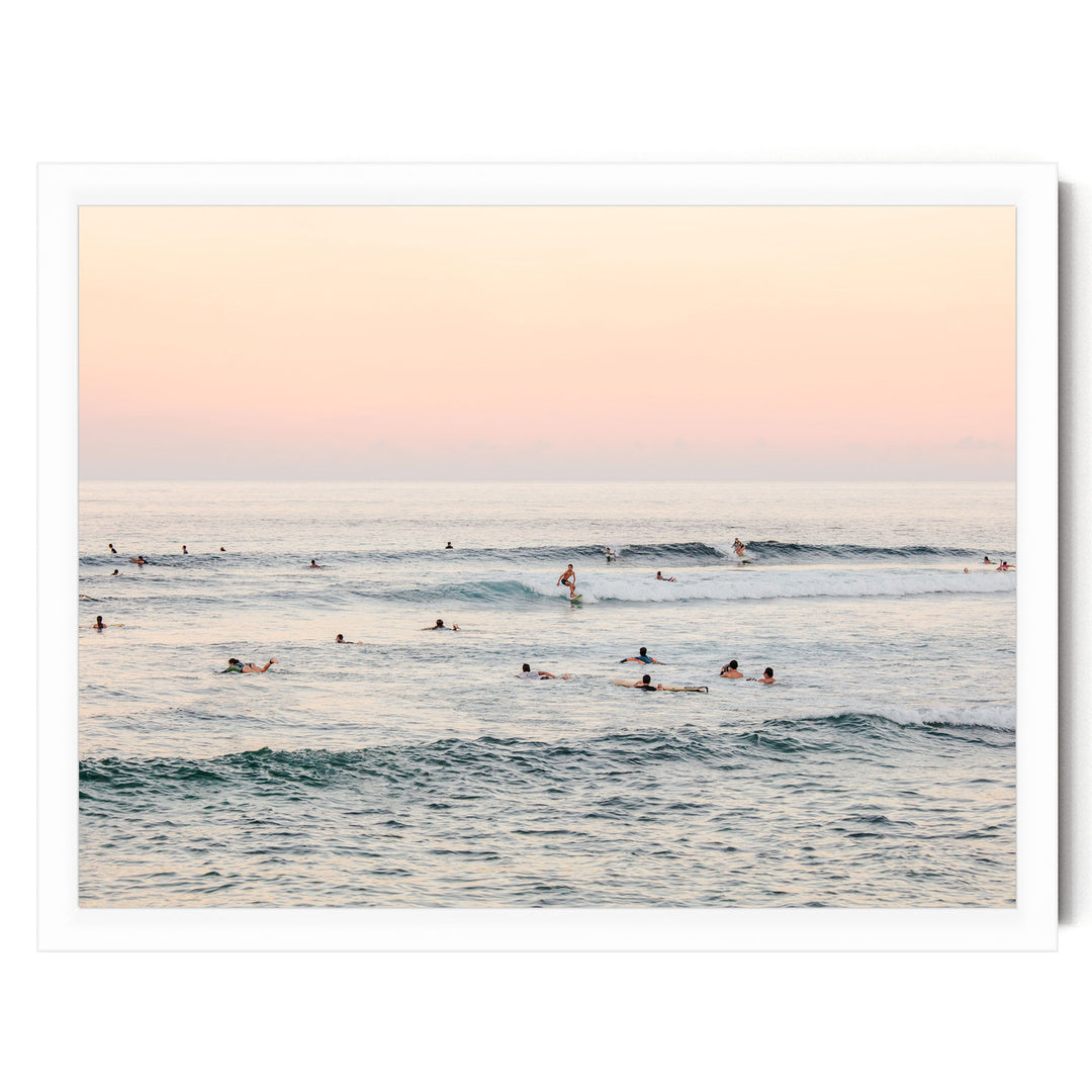 a group of people enjoying themselves in the ocean, with some of them surfing on the waves.