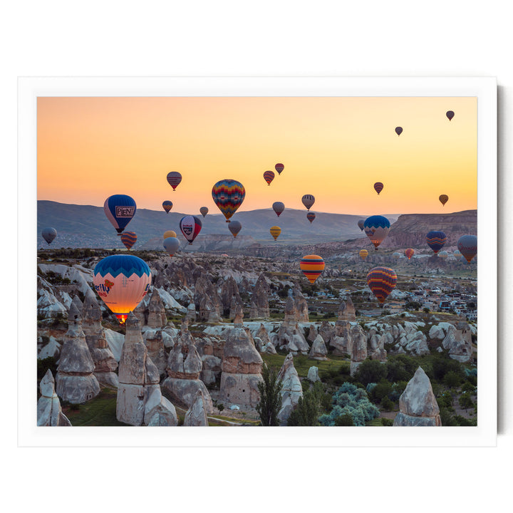 a breathtaking scene of hot air balloons floating over a mountainous landscape at sunset.