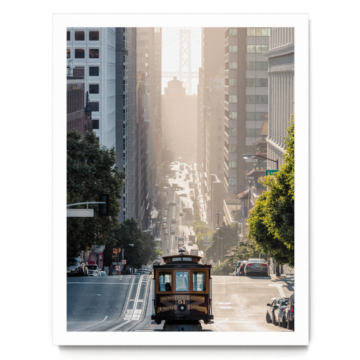 A cable car travels down a busy street in San Francisco, surrounded by tall buildings and lush green trees.