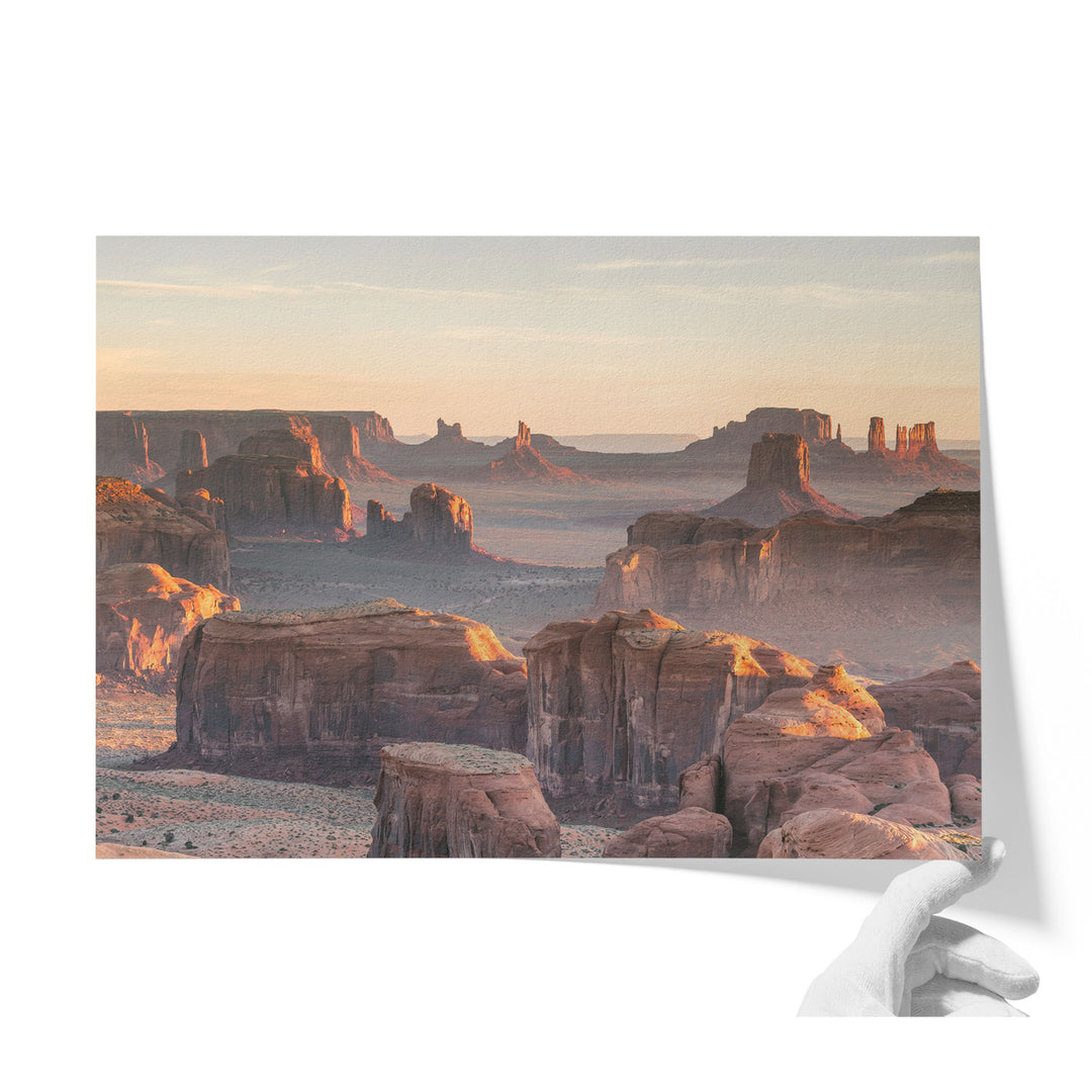 a breathtaking view of the Grand Canyon, showcasing its vast and rugged landscape with towering rock formations bathed in the warm glow of the setting sun.