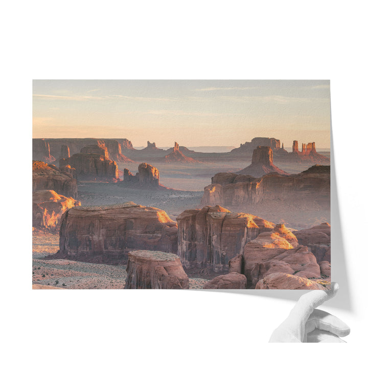 a breathtaking view of the Grand Canyon, showcasing its vast and rugged landscape with towering rock formations bathed in the warm glow of the setting sun.