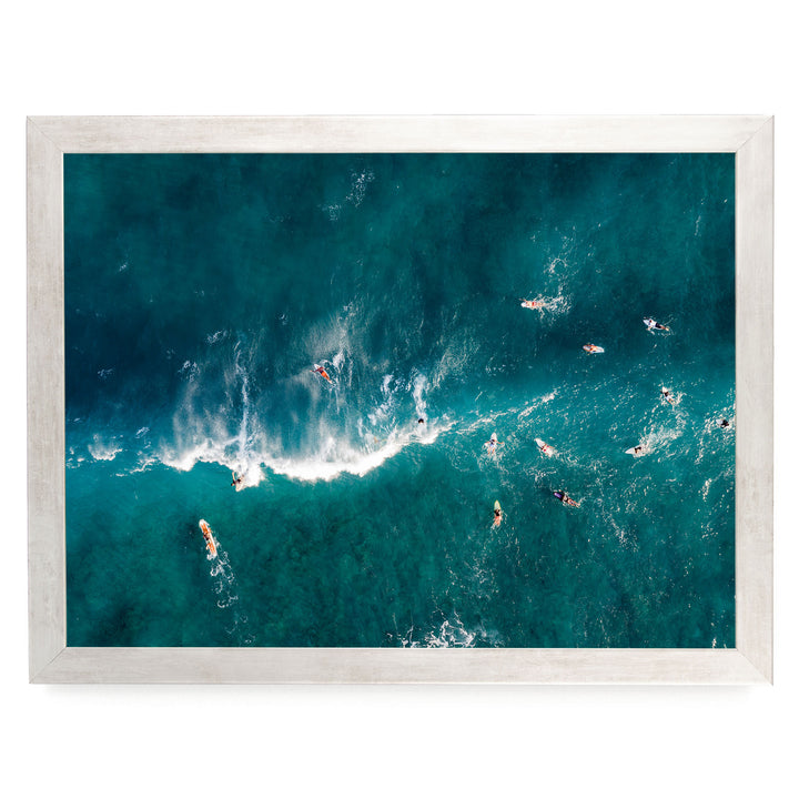a group of people surfing in the ocean, with waves crashing around them.