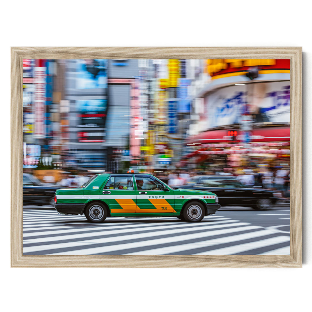 A green taxi cab is driving through a busy city street with colorful buildings and pedestrians in the background.