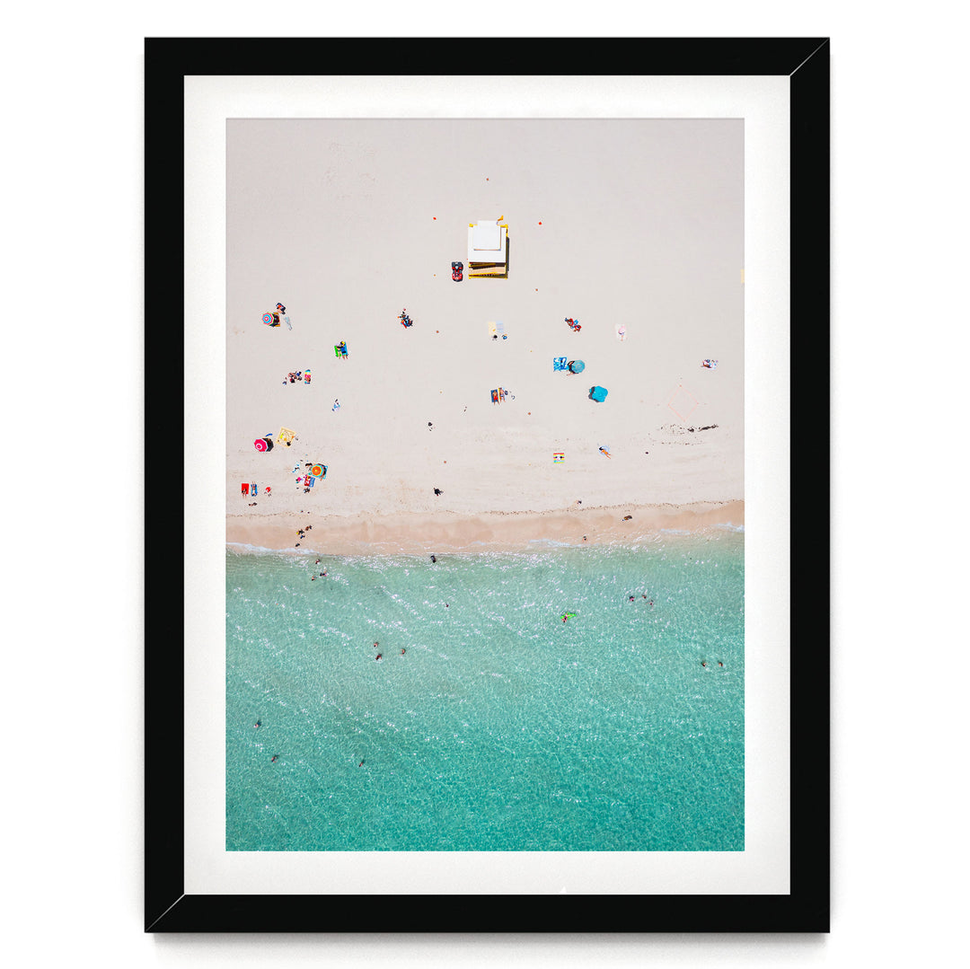 a beach scene with people enjoying the sun and water, featuring a clear turquoise ocean and a sandy beach.