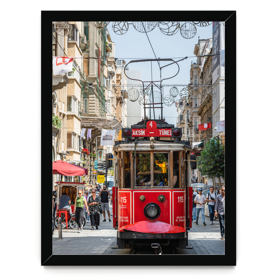 A red trolley car is traveling down a busy street in Istanbul, Turkey, surrounded by pedestrians and other vehicles.