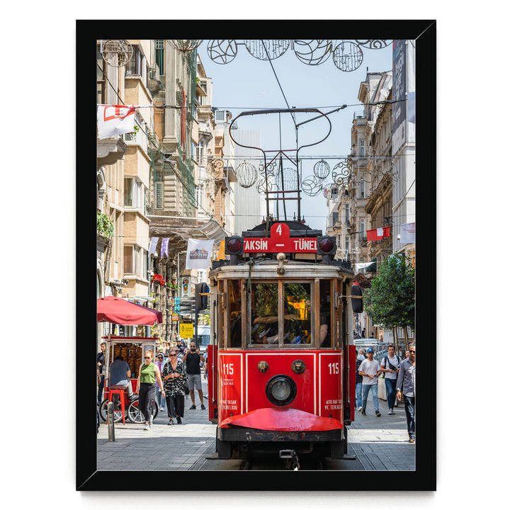 A red trolley car is traveling down a busy street in Istanbul, Turkey, surrounded by pedestrians and other vehicles.