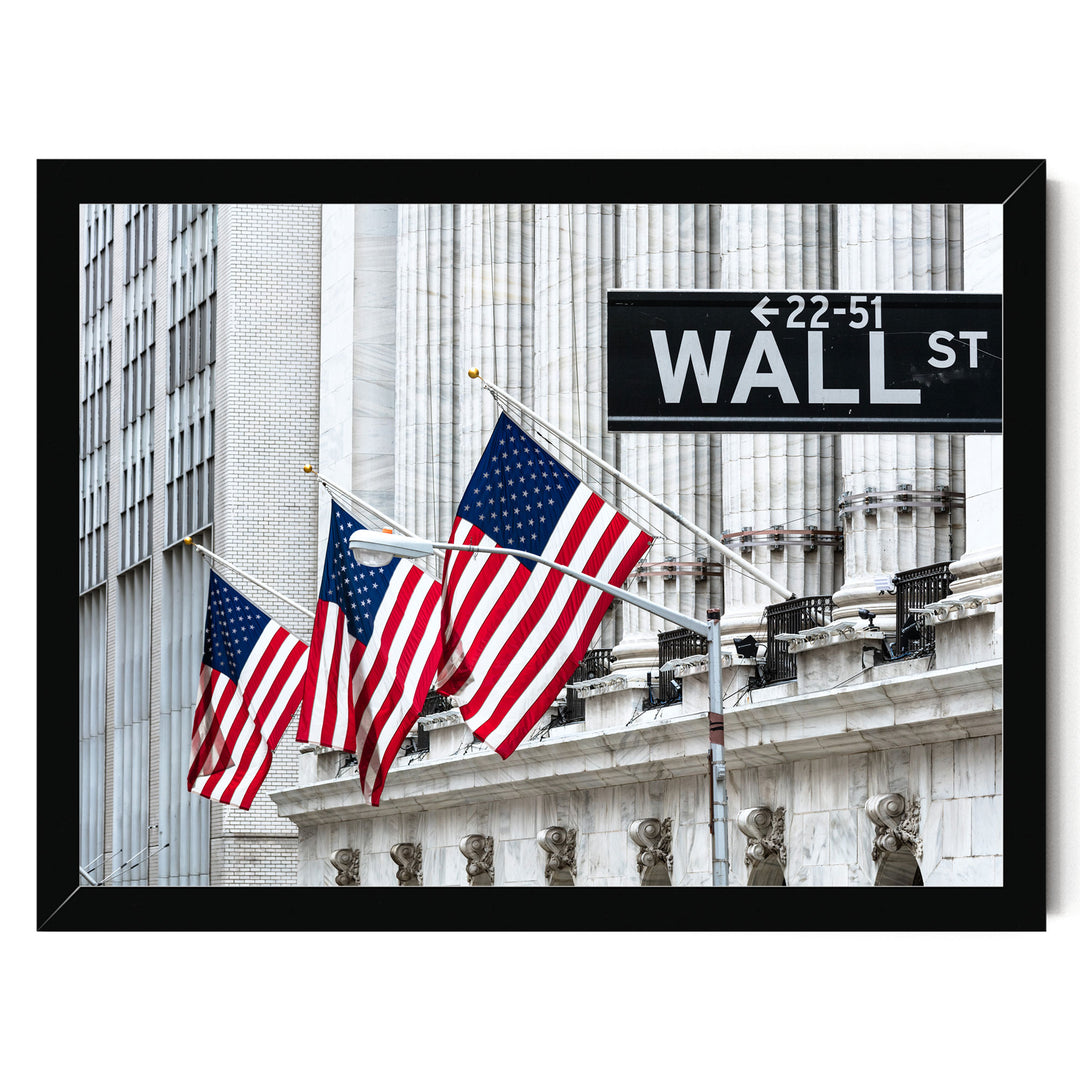 three American flags flying in front of a building with a Wall Street sign.