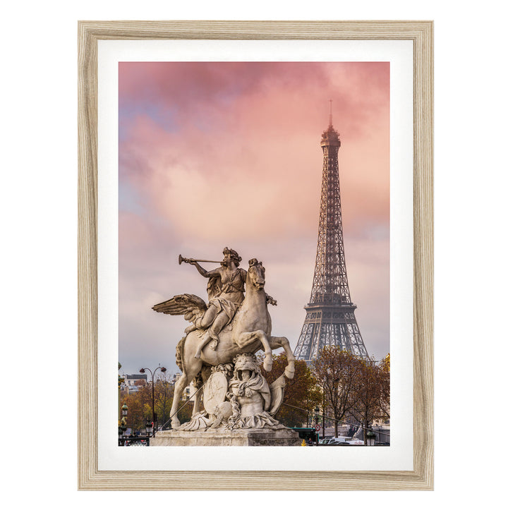 a statue of a winged man riding a rearing horse, with the Eiffel Tower visible in the background against a pink and purple sky.