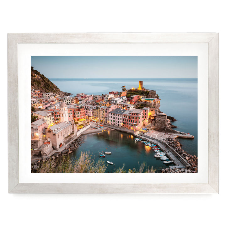 a picturesque coastal town with colorful buildings, a harbor, and a lighthouse on a cliff overlooking the water.