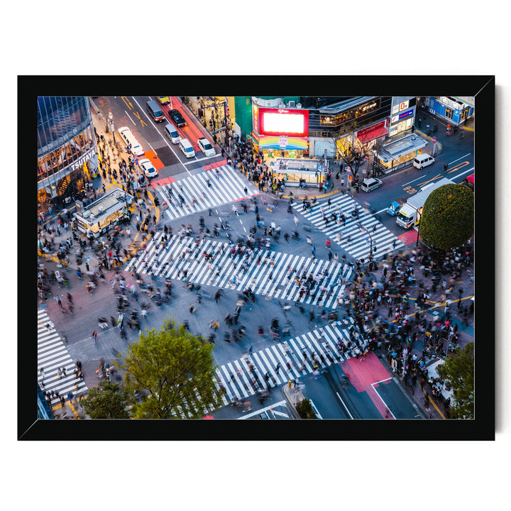 a busy city intersection with a large crowd of people crossing the street, surrounded by tall buildings, billboards, and various vehicles.