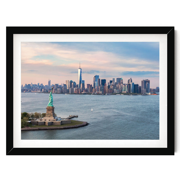 the Statue of Liberty on a small island in the foreground, with the New York City skyline visible in the background.