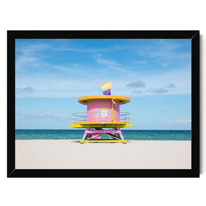 A brightly colored lifeguard tower stands on a sandy beach, overlooking the ocean.
