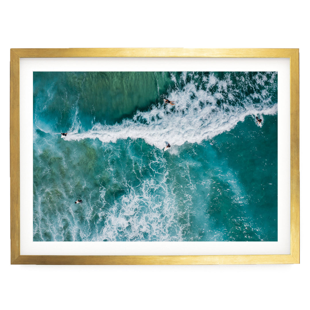 a group of people surfing on a large, turquoise wave in the ocean.