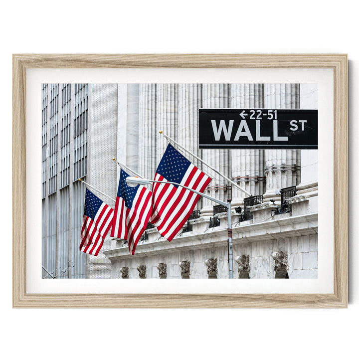 A framed photograph of the Wall Street building with three American flags flying in front of it.