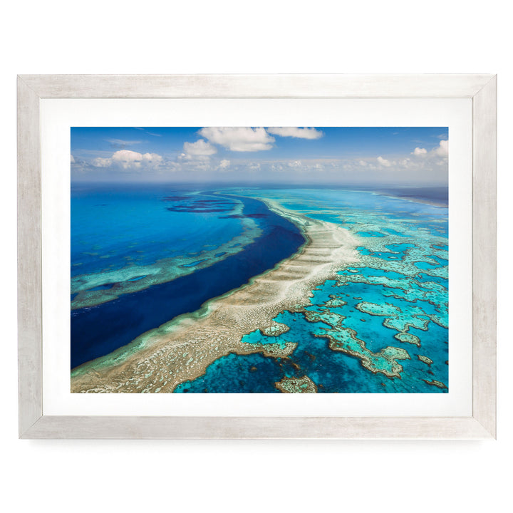 The image is a stunning aerial view of a vibrant coral reef, showcasing the intricate and diverse ecosystem beneath the ocean's surface.