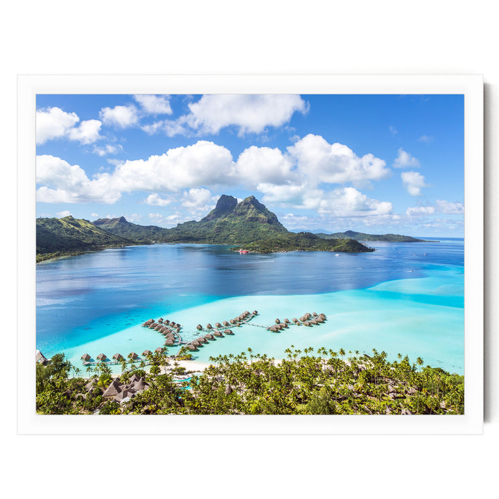 a tropical island with crystal clear turquoise waters, surrounded by lush green vegetation and dotted with several small islands.