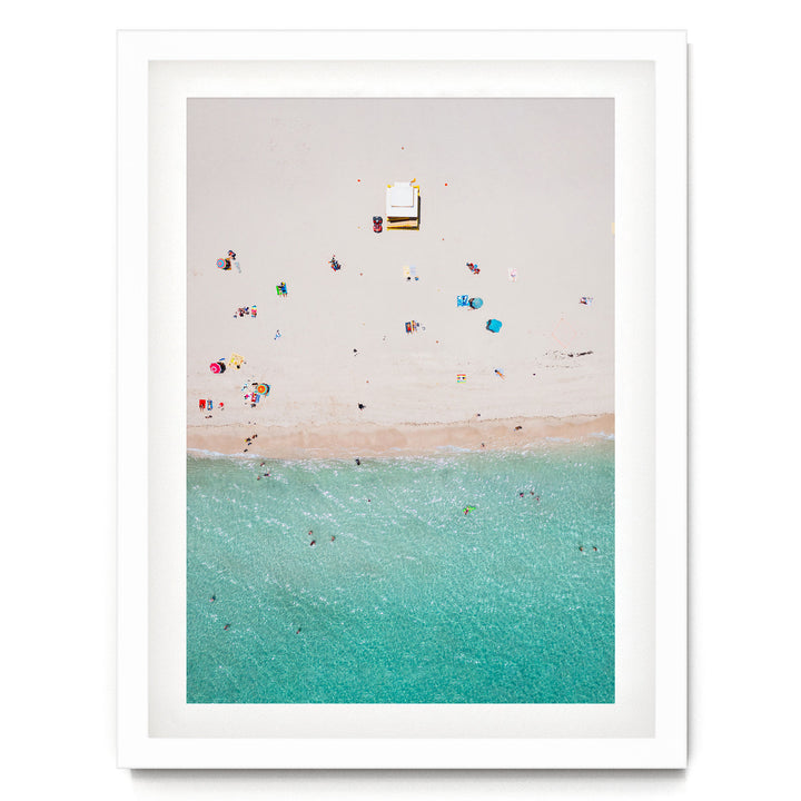 a beach scene with people enjoying the sun and the water, with a small white structure visible in the distance.