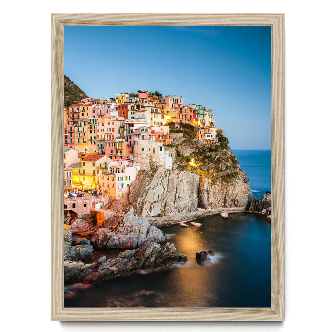 a picturesque coastal town nestled on a cliff, with its buildings painted in a vibrant array of colors and illuminated by warm lighting, creating a stunning and charming scene.