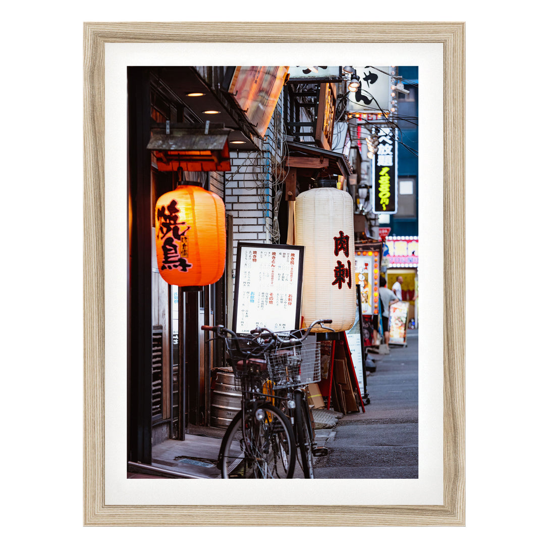 A bicycle parked on a street lined with colorful lanterns and signs, creating a vibrant and lively atmosphere.