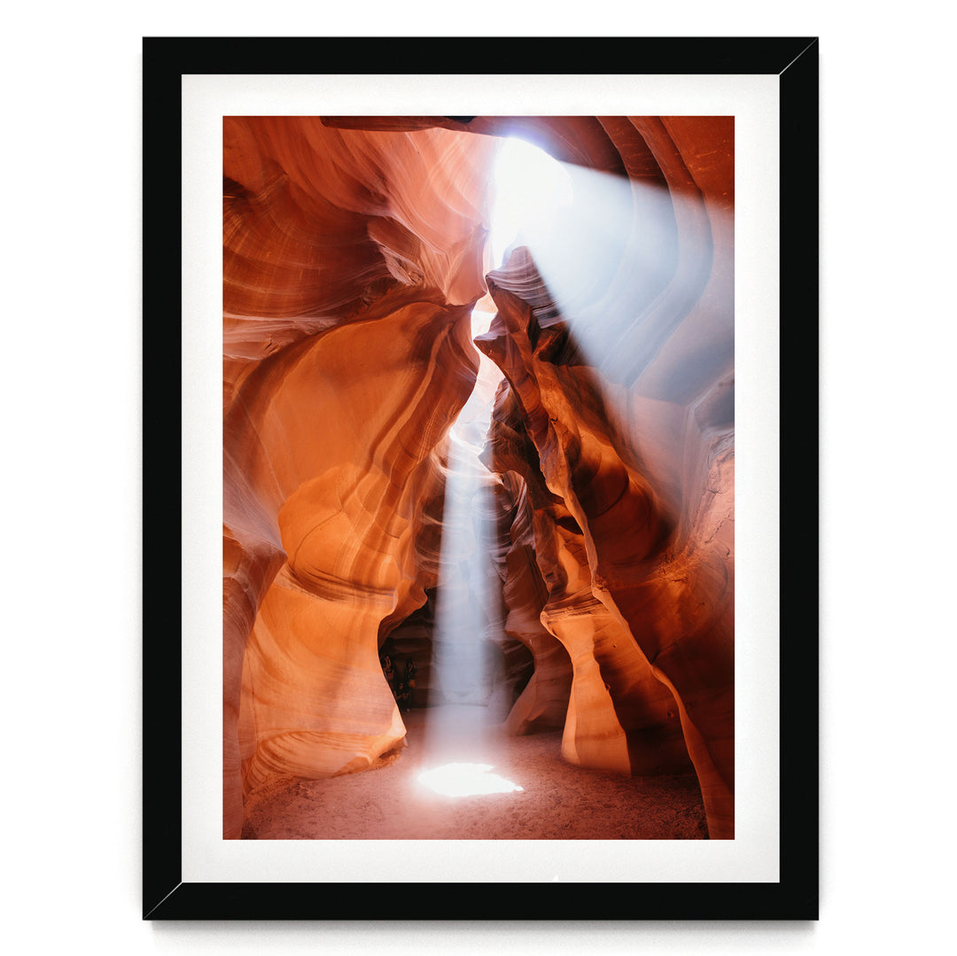 a stunning natural rock formation with a bright light shining through the narrow passage, creating a dramatic and captivating scene.