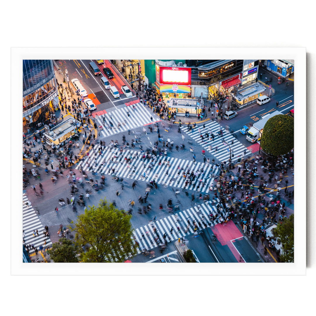 a busy city intersection with a large crowd of people crossing the street, surrounded by tall buildings and illuminated by colorful lights.