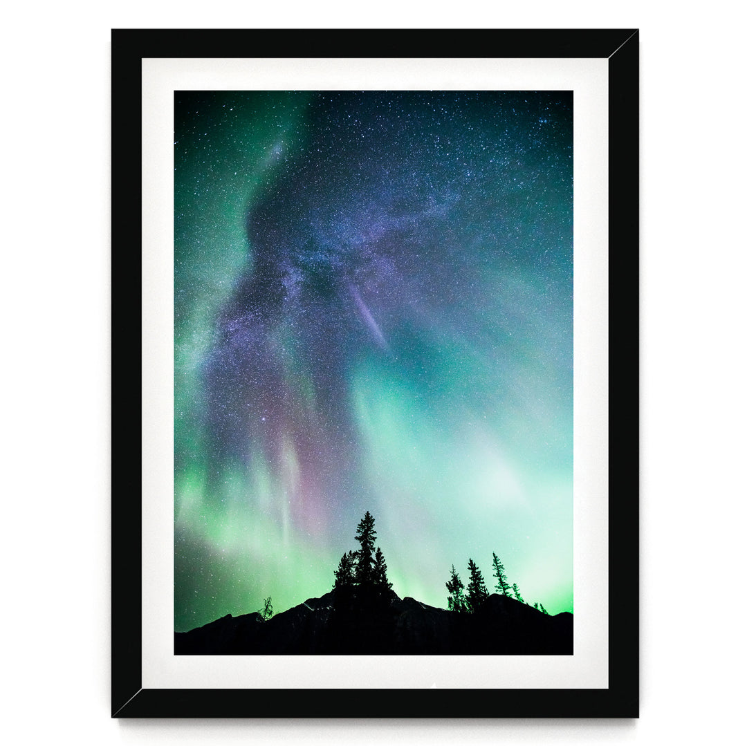 a stunning night sky with a vibrant display of the Aurora Borealis, or Northern Lights, illuminating the sky above a silhouetted mountain range.