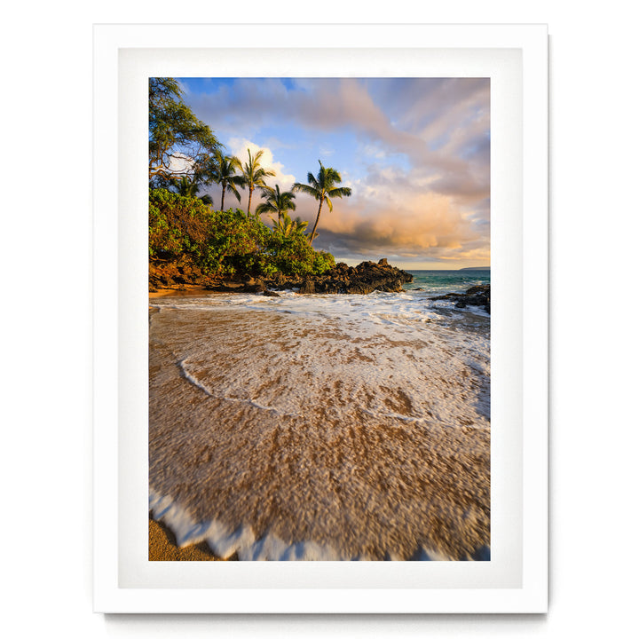 a serene beach scene with palm trees, a rocky shoreline, and crashing waves.