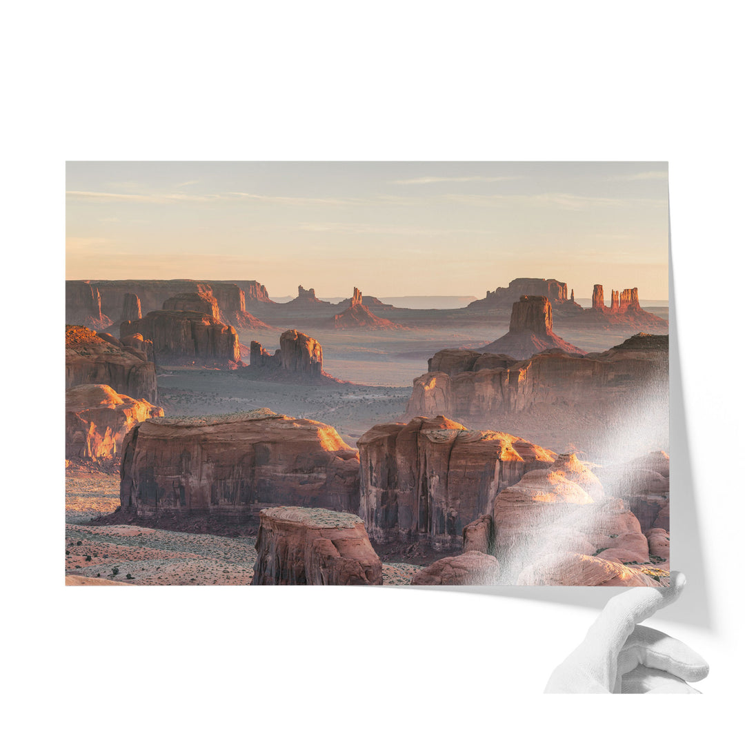 a breathtaking view of the Grand Canyon, showcasing its vast and rugged landscape with towering rock formations and a warm, golden glow from the setting sun.