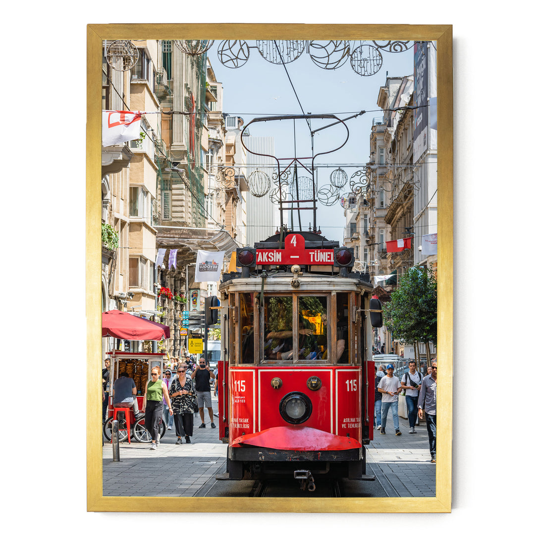 A red trolley car, numbered 115, is traveling down a busy street lined with buildings and pedestrians.