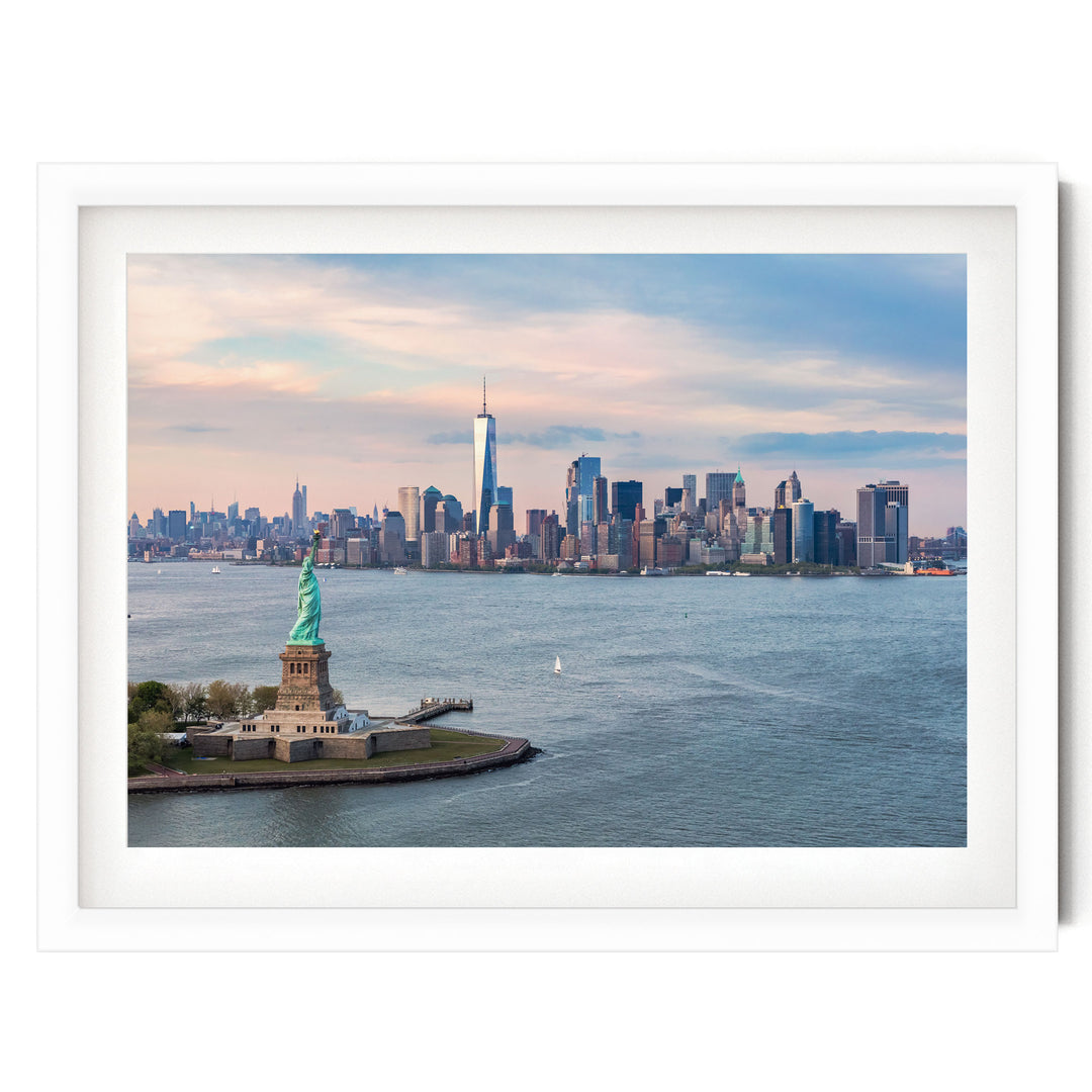 the Statue of Liberty on a small island in the foreground, with the New York City skyline in the background.